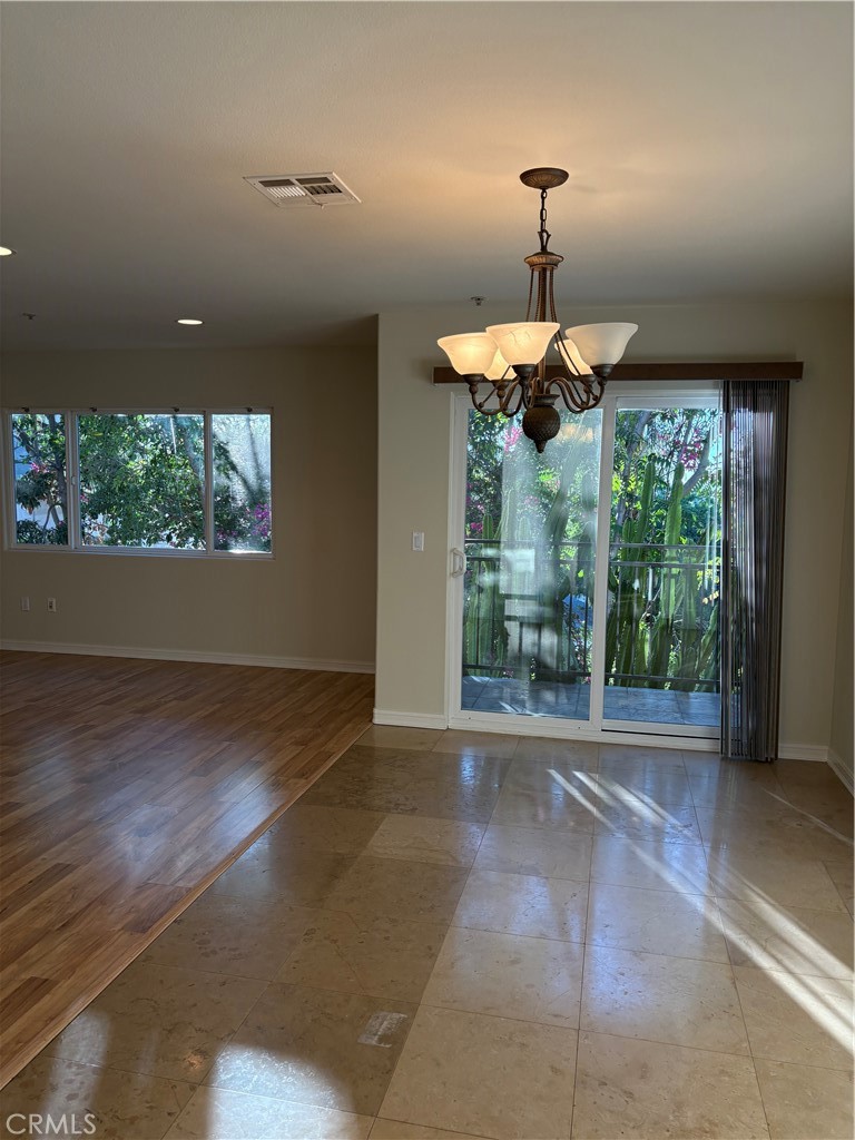 10207 Mountair Avenue, Unit 105 Tujunga, CA 91042 - Photo 9 of 32 a living room with a floor to ceiling window and a chandelier