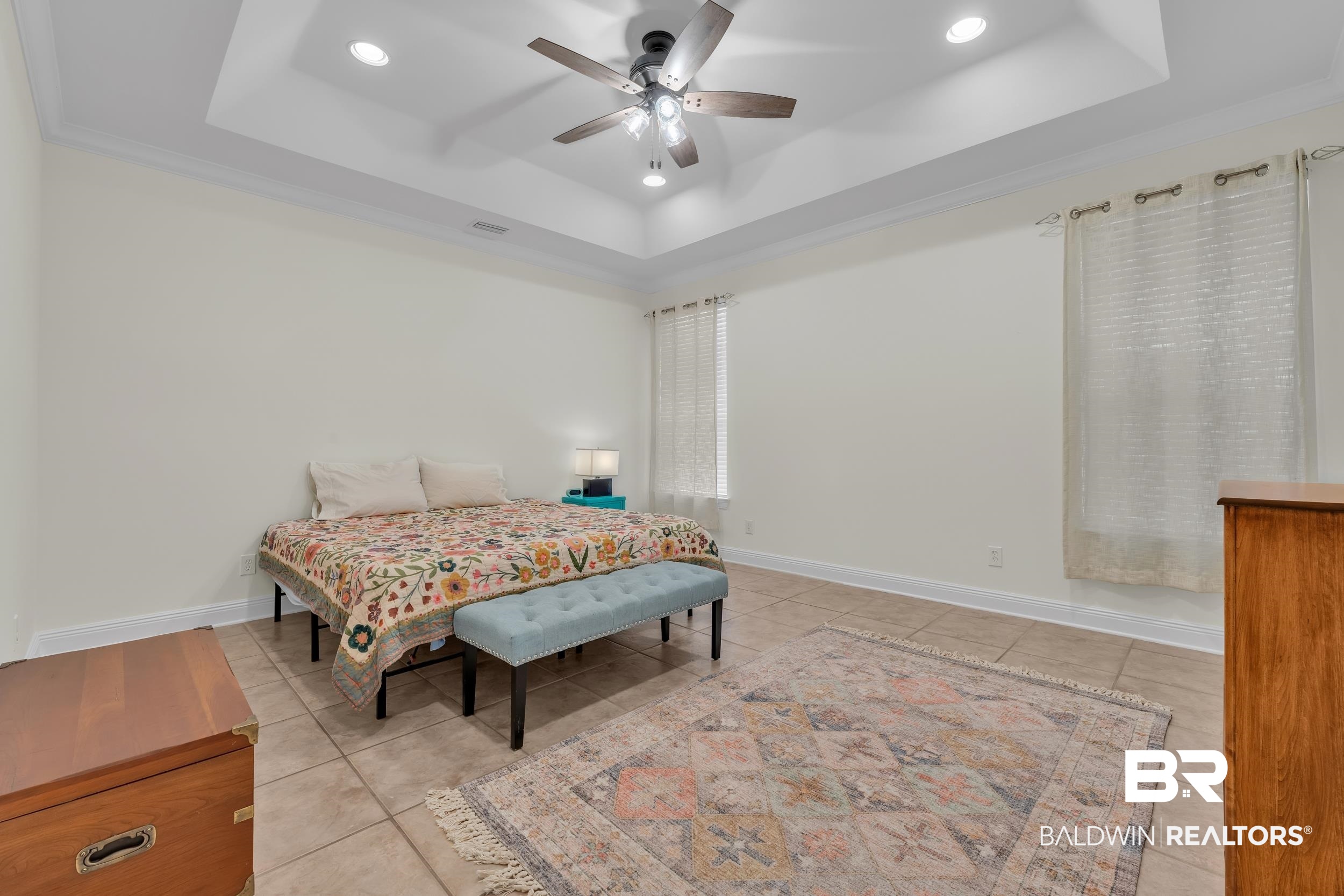4606 Osprey Drive Orange Beach, AL 36561 - Photo 26 of 44 Bedroom with a tray ceiling, tile patterned flooring, recessed lighting, a ceiling fan, and crown molding