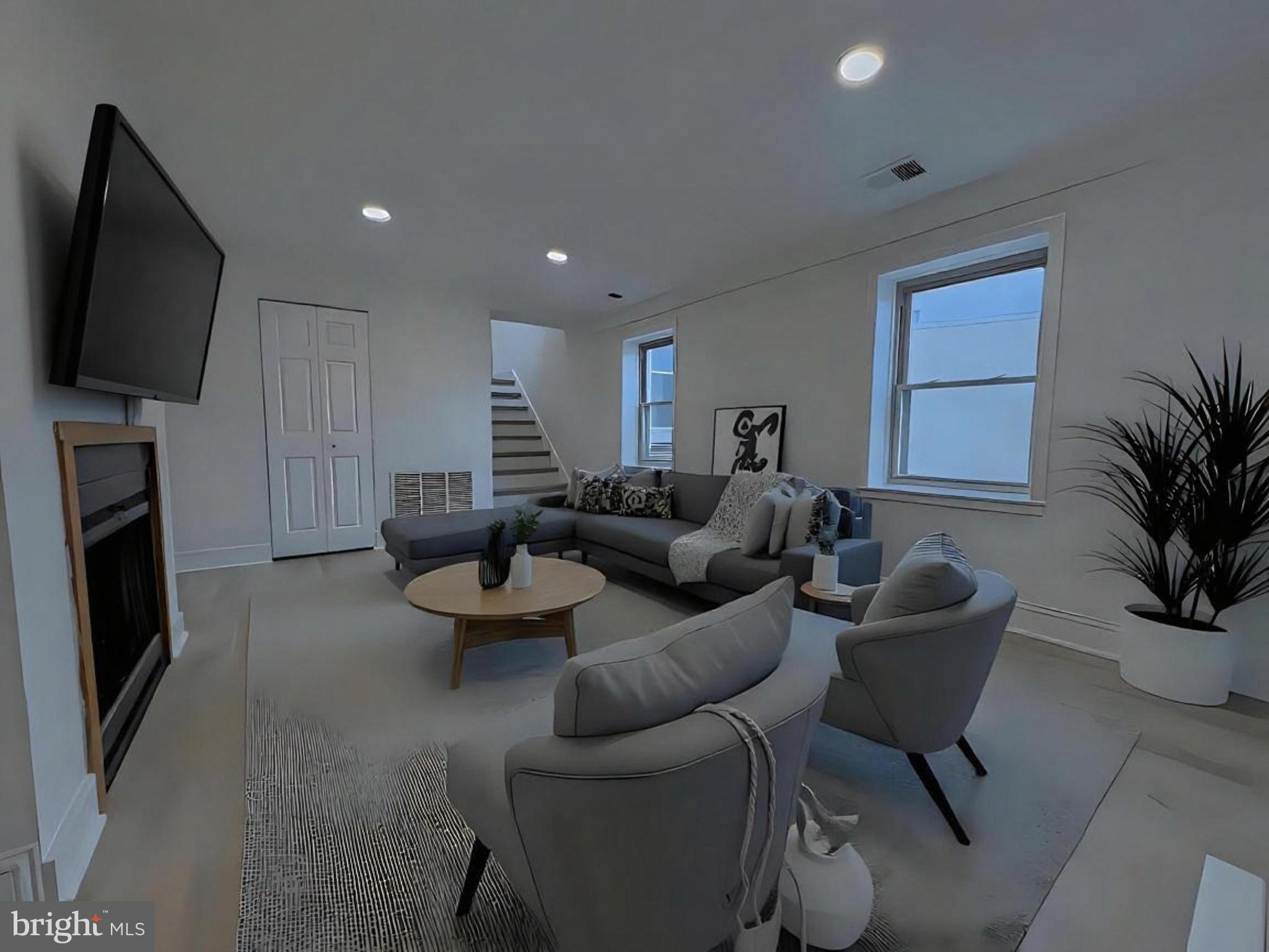 a living room with furniture a flat screen tv and a fireplace