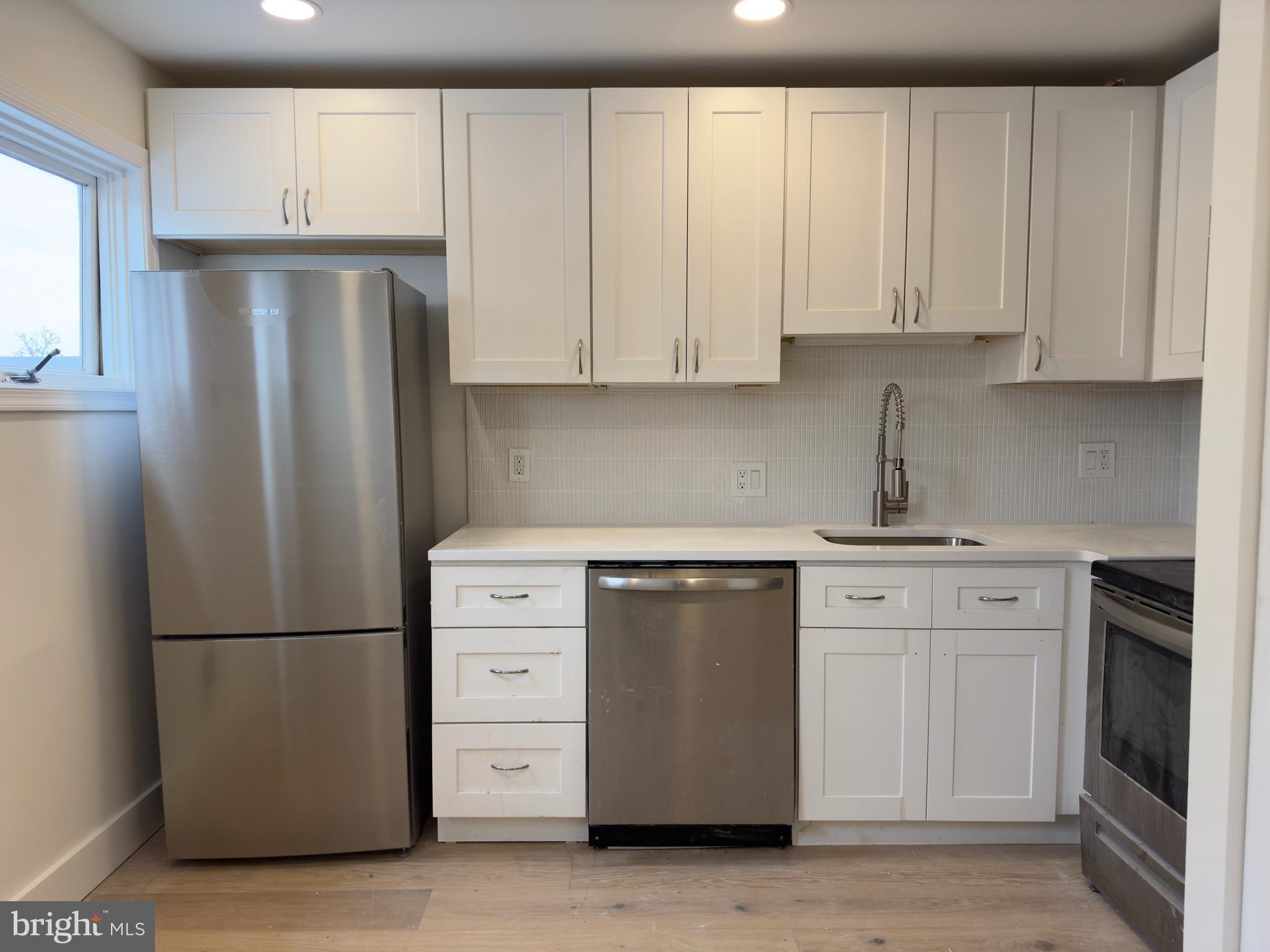 1703 Green Street, Unit 7 Philadelphia, PA 19130 - Photo 2 of 12 a kitchen with stainless steel appliances granite countertop a refrigerator sink and cabinets