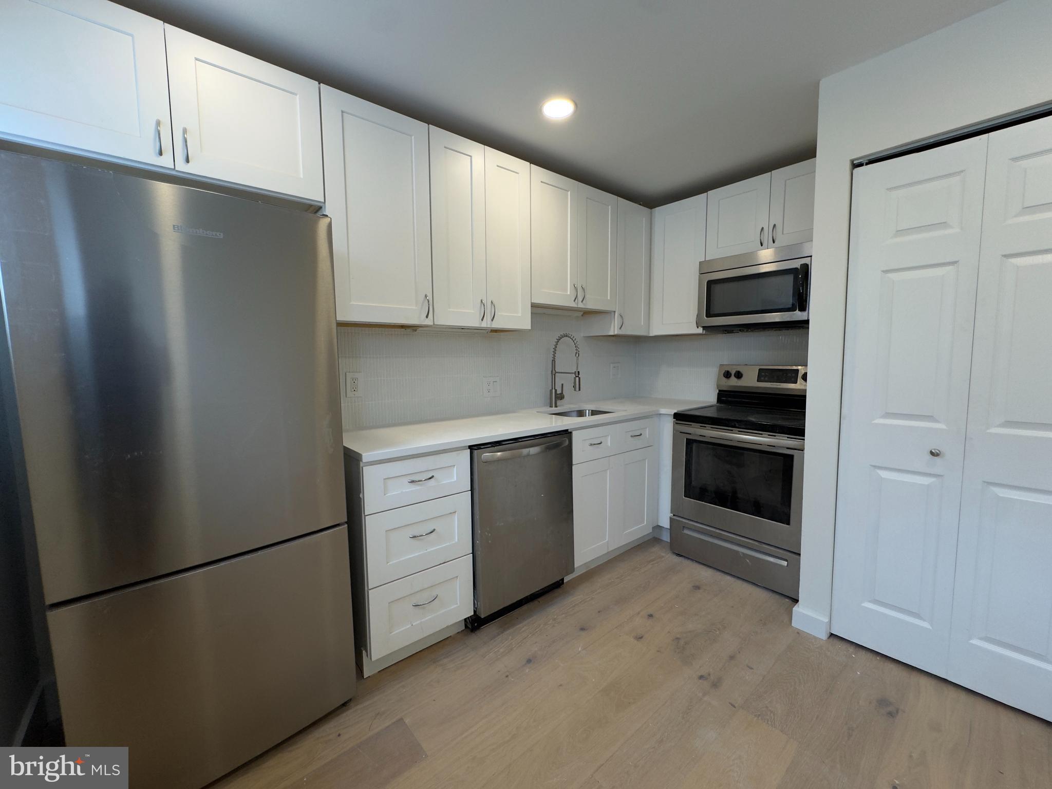1703 Green Street, Unit 7 Philadelphia, PA 19130 - Photo 3 of 12 a kitchen with white cabinets and white appliances