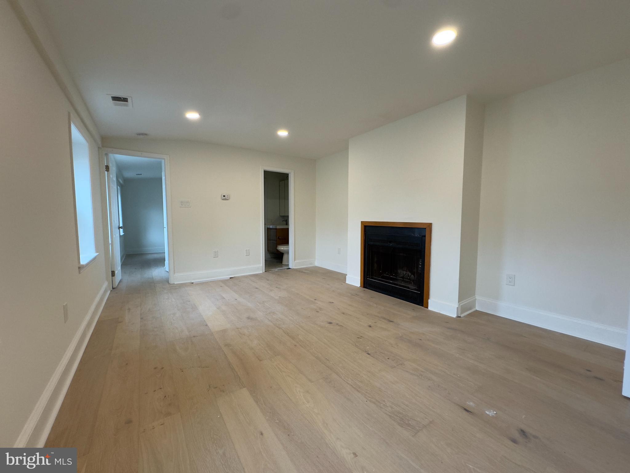 1703 Green Street, Unit 7 Philadelphia, PA 19130 - Photo 6 of 12 an empty room with a fireplace and a window
