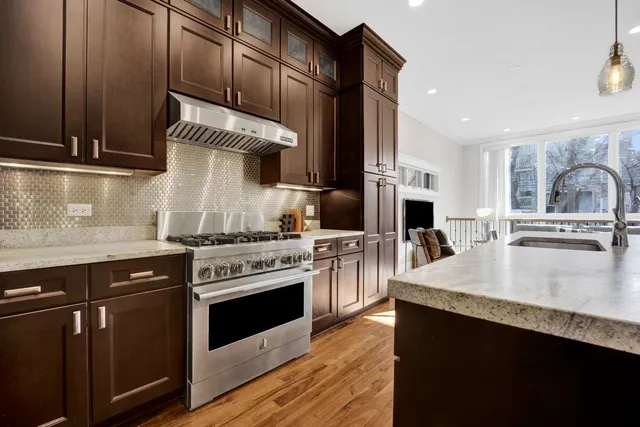 a kitchen with stainless steel appliances granite countertop a stove a sink and a microwave