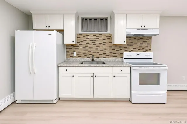 a kitchen with granite countertop white cabinets and white appliances