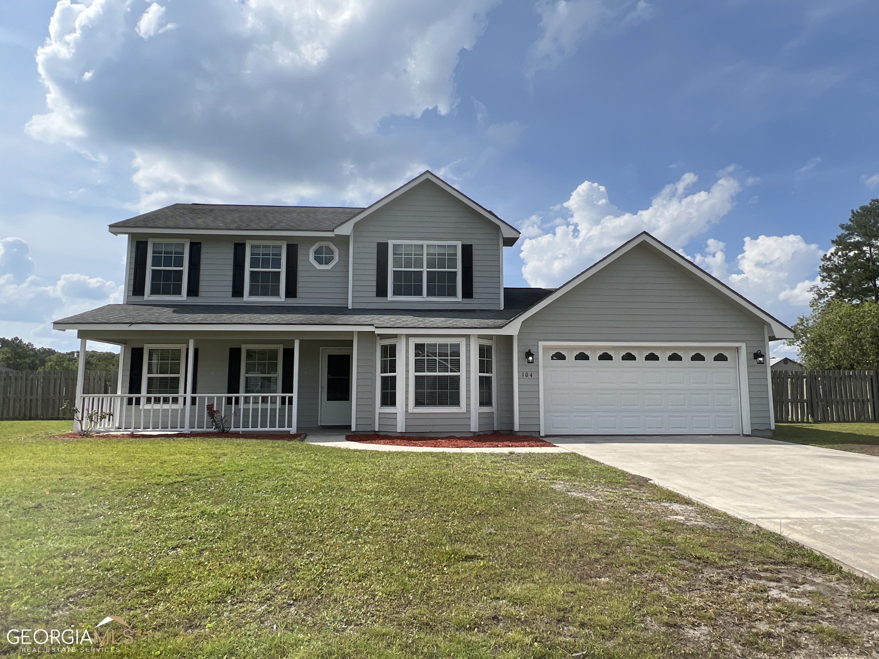 a view of a house with a yard and large trees