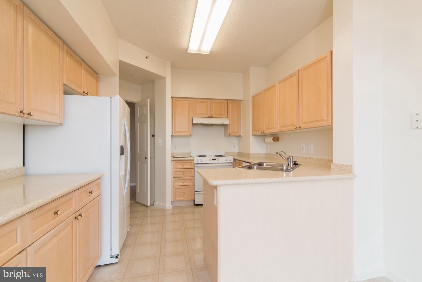 19365 Cypress Ridge Terrace, Unit 918 Leesburg, VA 20176 - Photo 3 of 8 a kitchen with a sink a refrigerator and a stove