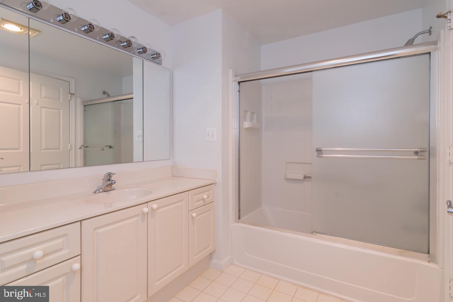 19365 Cypress Ridge Terrace, Unit 918 Leesburg, VA 20176 - Photo 4 of 8 a bathroom with a granite countertop sink mirror and a bathtub