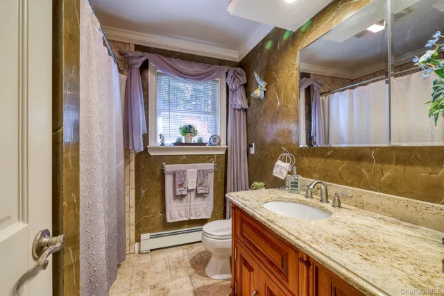 a bathroom with a granite countertop sink a mirror and a shower