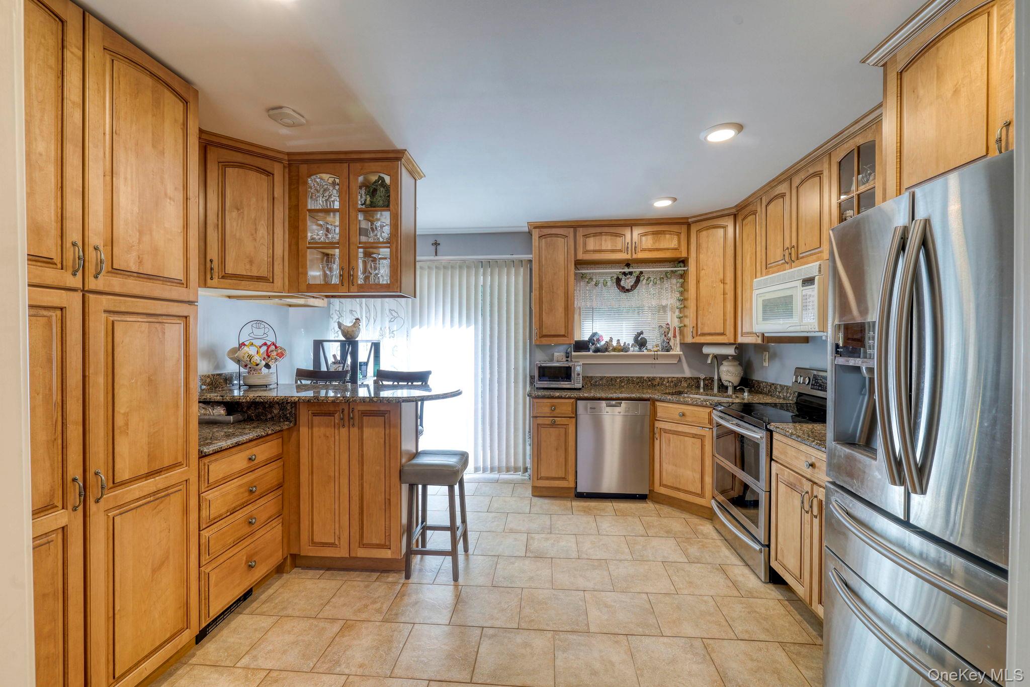 135 Barrett Hill Road Carmel, NY 10512 - Photo 8 of 37 a kitchen with granite countertop stainless steel appliances and wooden cabinets