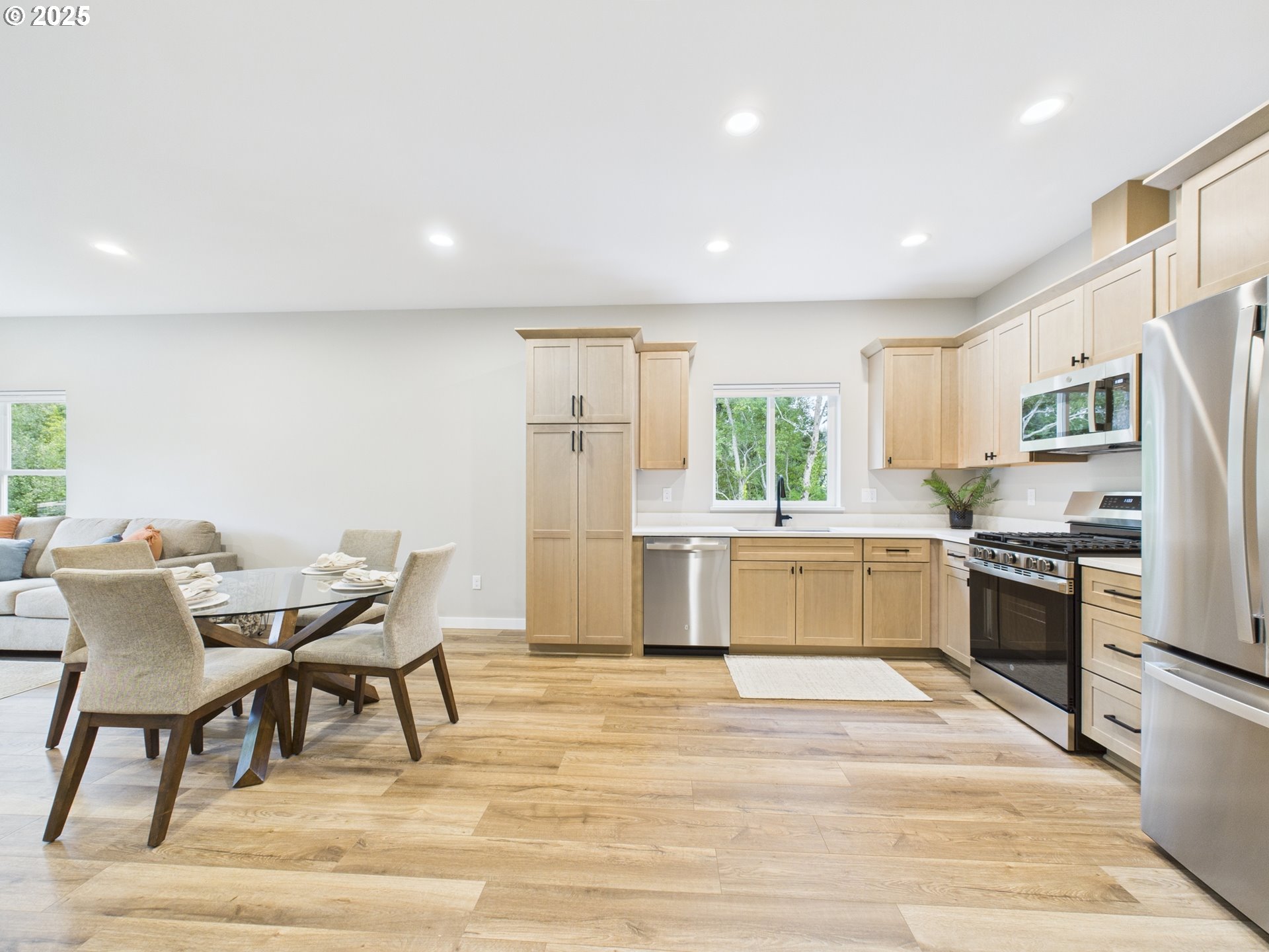 1269 Avenue D Seaside, OR 97138 - Photo 17 of 22 a kitchen with stainless steel appliances kitchen island granite countertop a refrigerator a stove top oven a sink dishwasher and white cabinets with wooden floor