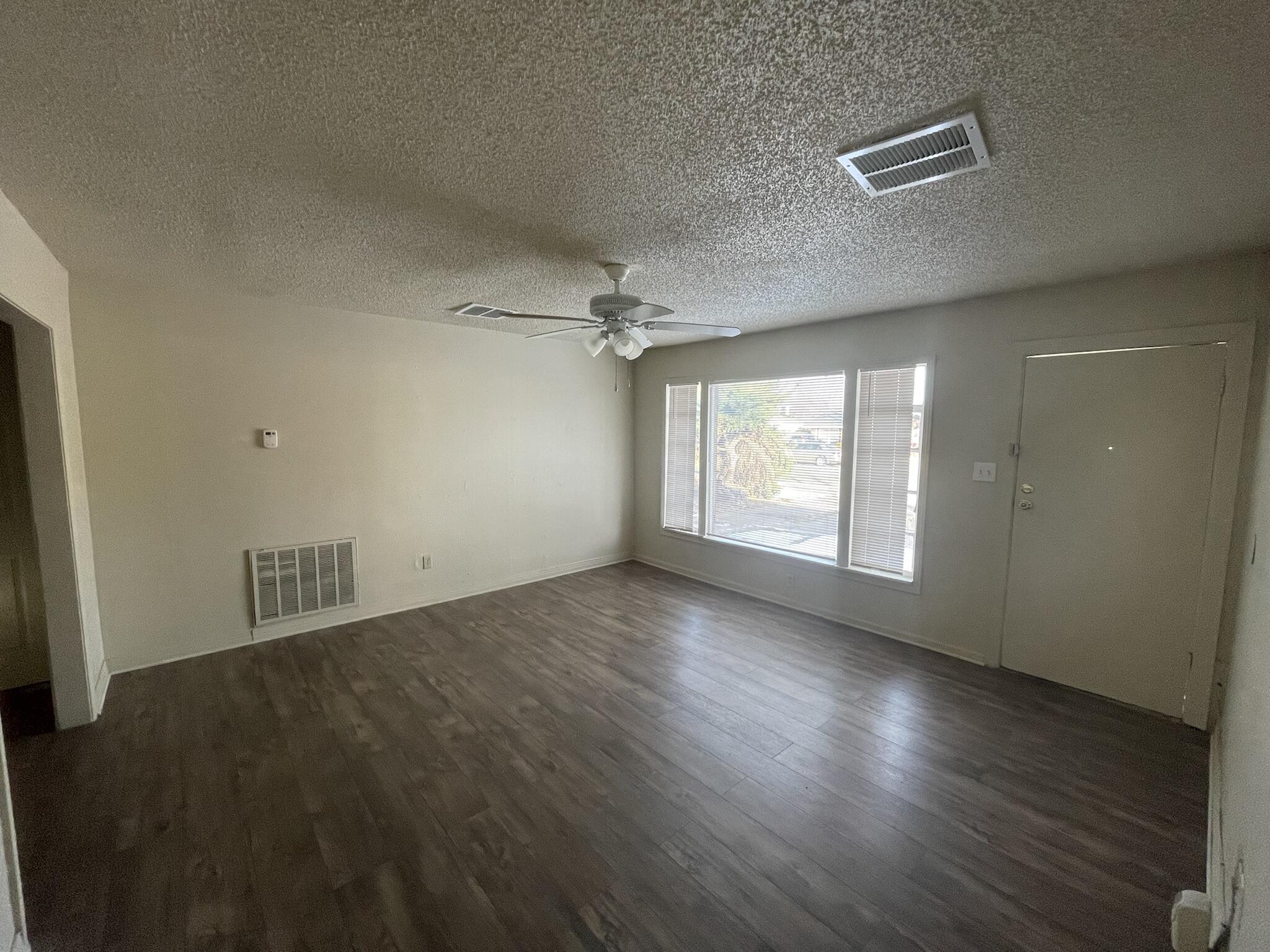 4303 42nd Street Lubbock, TX 79413 - Photo 3 of 10 an empty room with wooden floor and windows