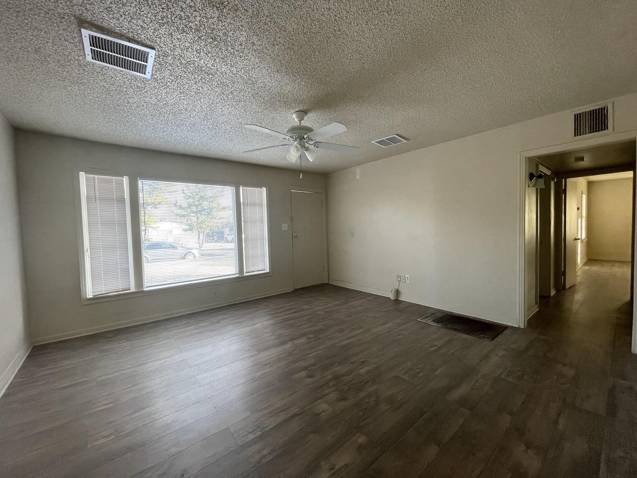 4303 42nd Street Lubbock, TX 79413 - Photo 4 of 10 an empty room with wooden floor and windows
