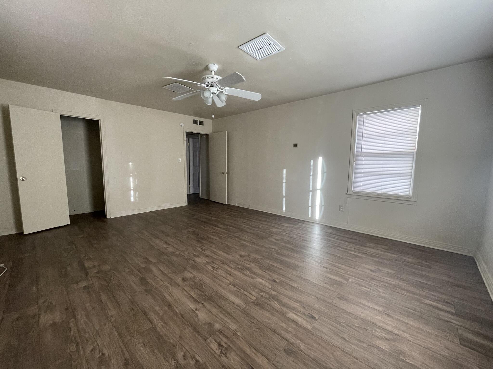 4303 42nd Street Lubbock, TX 79413 - Photo 8 of 10 an empty room with wooden floor and windows