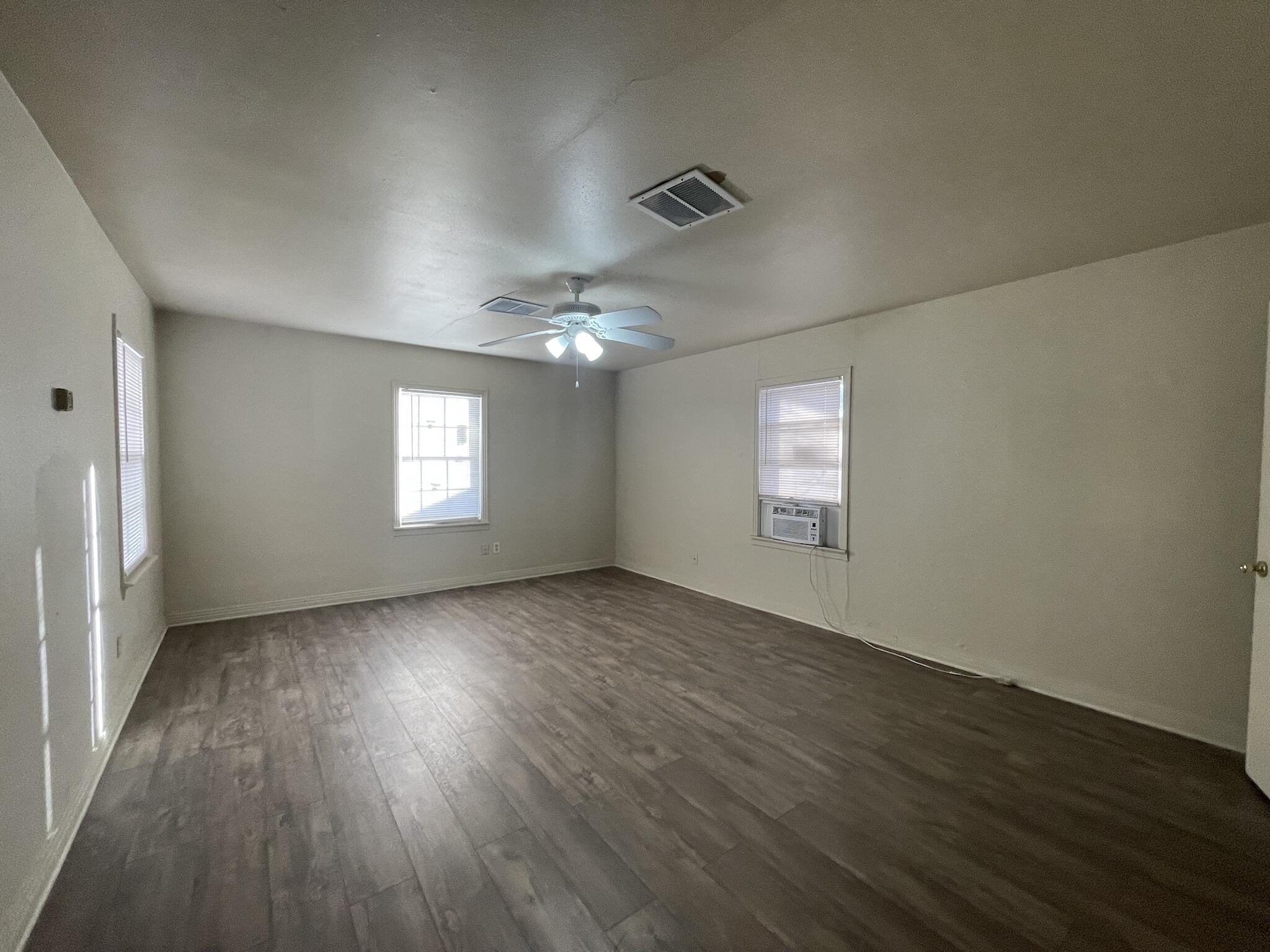 4303 42nd Street Lubbock, TX 79413 - Photo 10 of 10 an empty room with wooden floor and windows