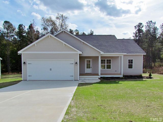 a view of a yard in front of a house with plants and a garden