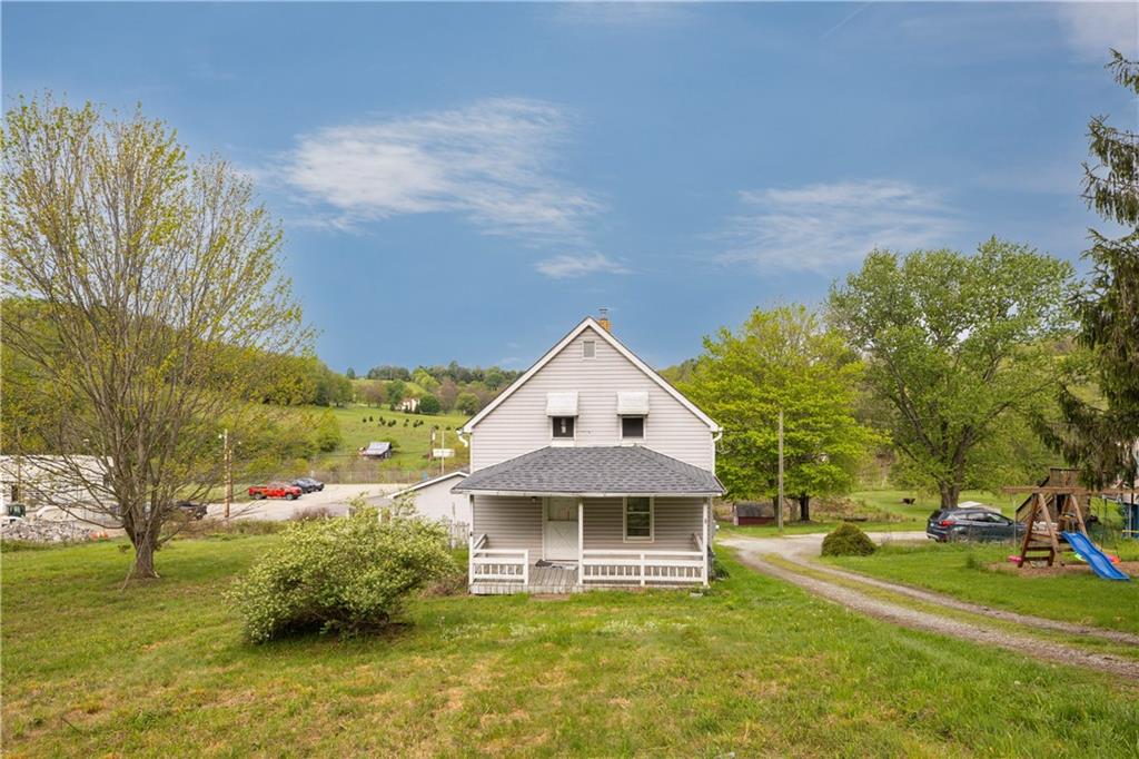 a front view of a house with a garden and trees