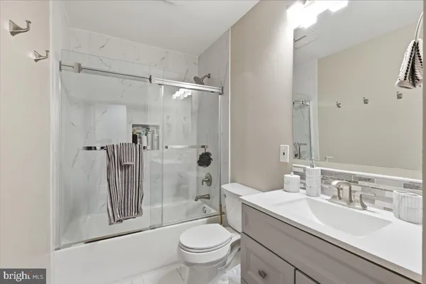 a bathroom with a granite countertop sink toilet and shower