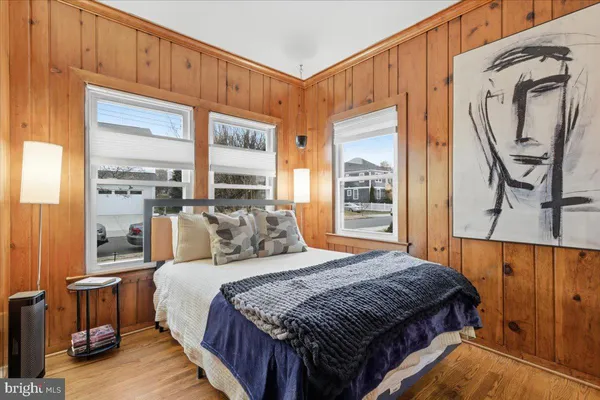 a bedroom with a bed a mirror and a window