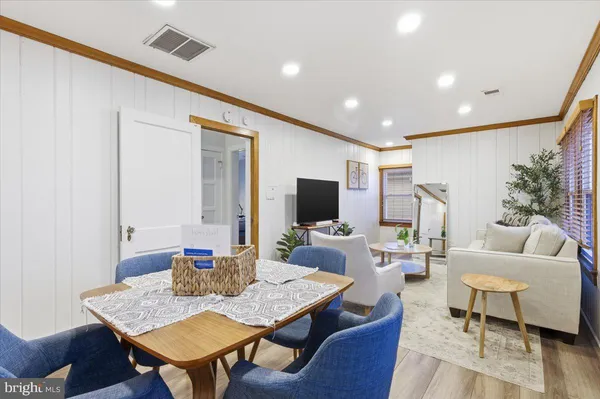 a living room with furniture kitchen view and a large window