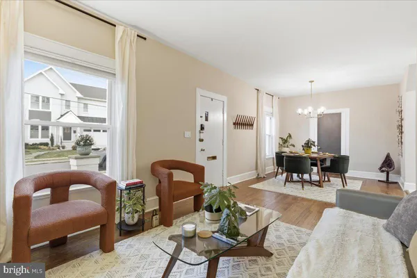 a living room with furniture a dining table and a large window