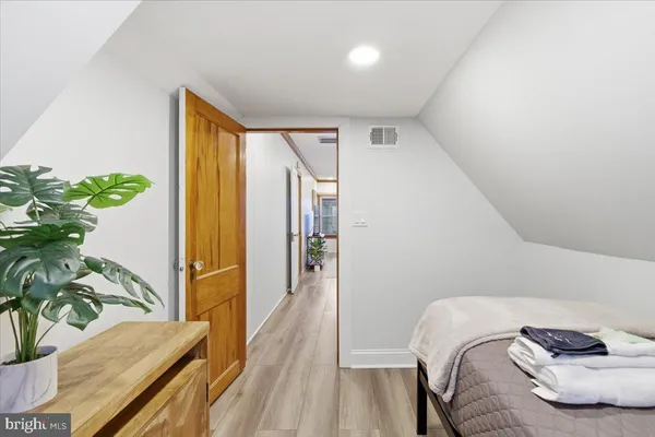 a bedroom with a bed and a potted plant