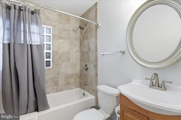 a bathroom with a sink a mirror a toilet and a bathtub