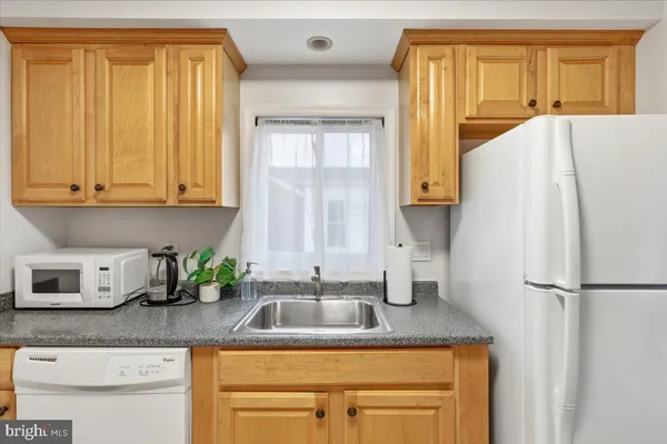 a kitchen with stainless steel appliances granite countertop a refrigerator sink and cabinets