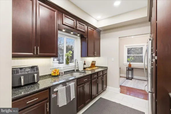 a kitchen with stainless steel appliances granite countertop a sink stove and cabinets
