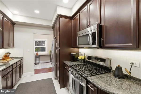 a kitchen with stainless steel appliances granite countertop a stove and a microwave