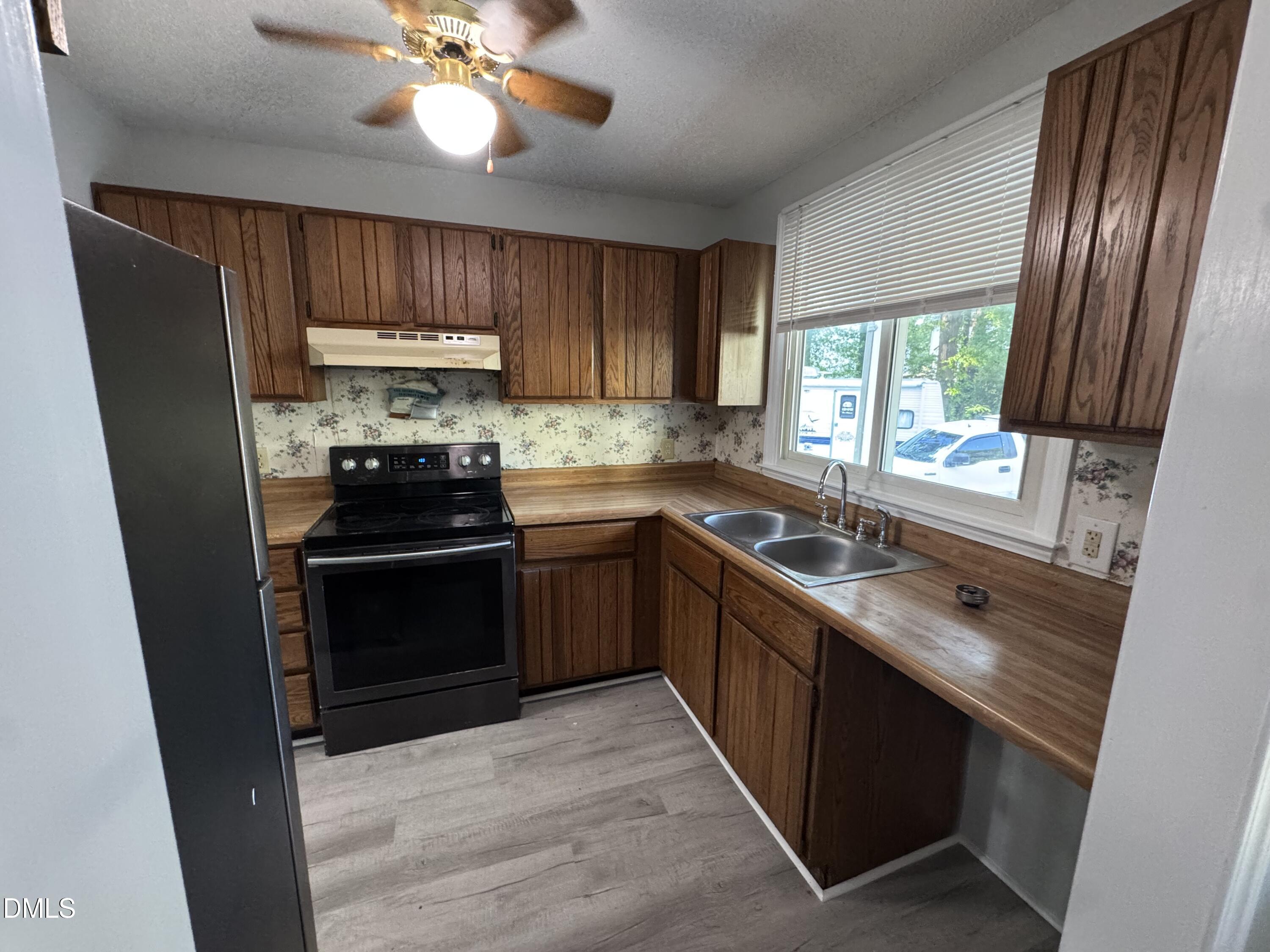4200 Bertram Drive Raleigh, NC 27604 - Photo 3 of 16 a kitchen with stainless steel appliances a stove a sink and a refrigerator