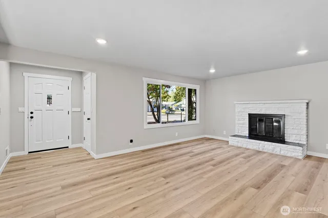 an empty room with windows and fireplace