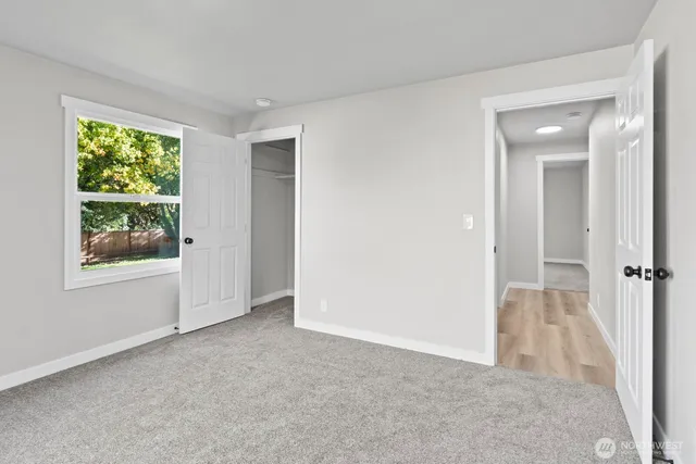 an empty room with windows and closet