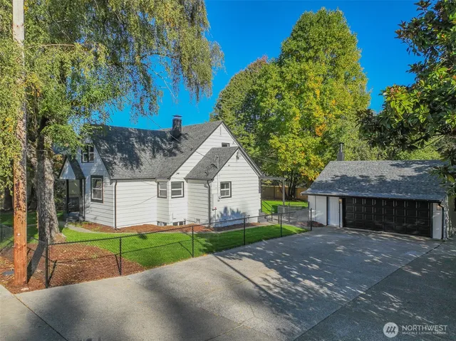 a front view of a house with a garden and trees