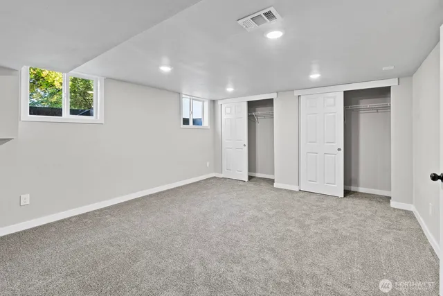 an empty room with windows and closet