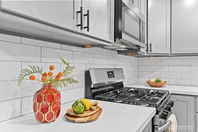 a table with a stove and a vase of flowers