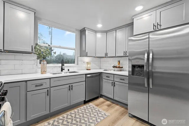 a kitchen with a sink stainless steel appliances and cabinets