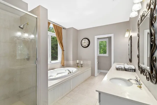 a bathroom with a tub sink and mirror