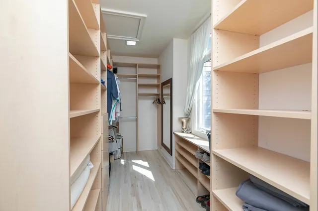 a view of walk in closet with empty racks