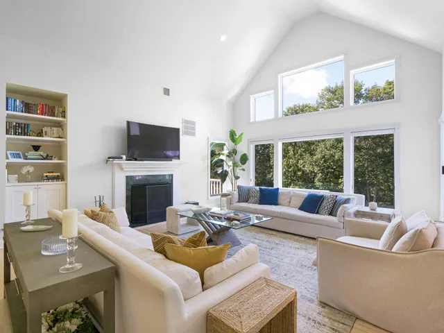 a living room with furniture a large window and a flat screen tv