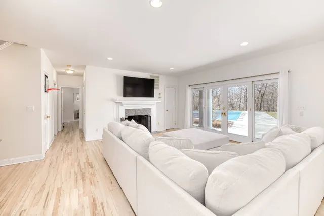 a living room with furniture a flat screen tv and a fireplace