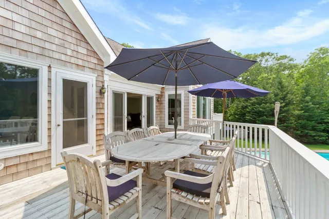 a view of a patio with a table and chairs under an umbrella