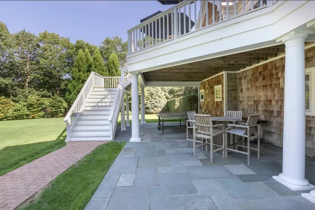 a view of a patio with table and chairs with wooden floor and fence