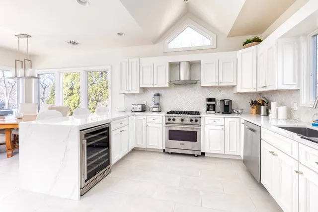a kitchen with white cabinets and white appliances