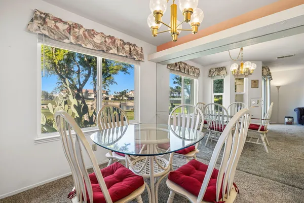 a kitchen with stainless steel appliances granite countertop a dining table and chairs