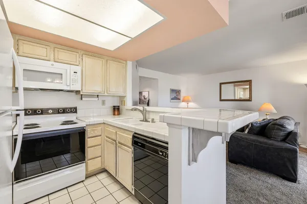 a living room with stainless steel appliances furniture and a flat screen tv