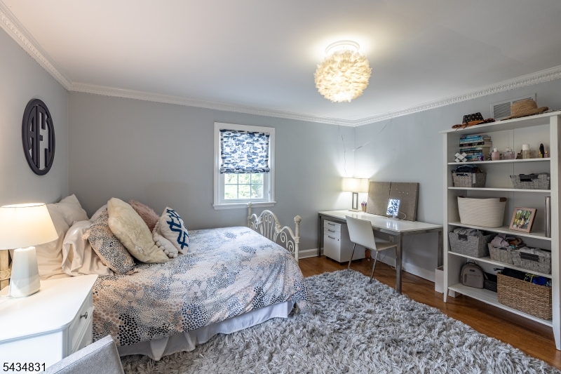 200 Wychwood Road Westfield, NJ 07090 - Photo 19 of 31 a bedroom with a bed and a chandelier