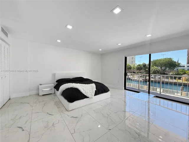 a spacious bedroom with a large bed and a large window