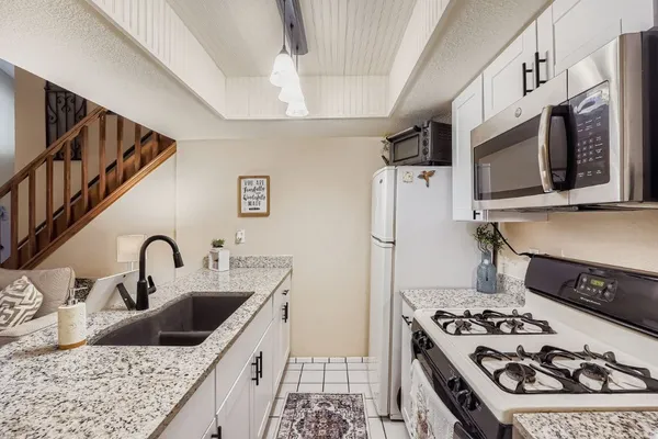 a kitchen with stainless steel appliances granite countertop a sink stove and refrigerator