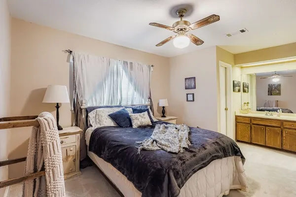 a bedroom with a large bed and a chandelier