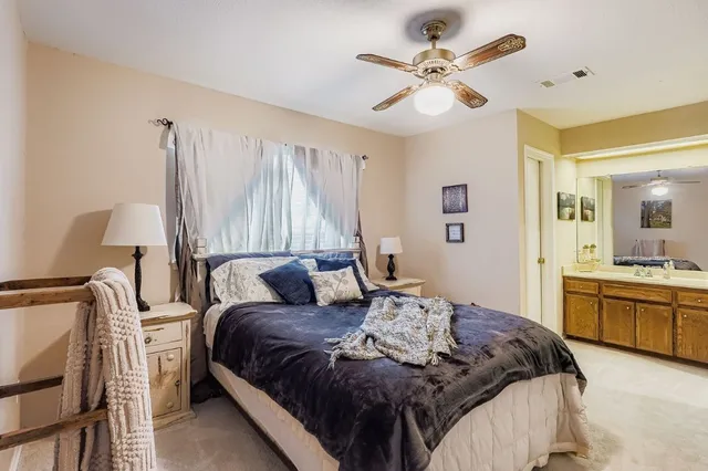 a bedroom with a large bed and a chandelier